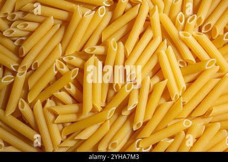 Pâtes Penne Rigate non cuites : une toile culinaire de Penne Macaroni, créant un fond vivant et texturé pour la cuisine gastronomique. Pâtes sèches. Macaroni brut - vue de dessus, plat Banque D'Images