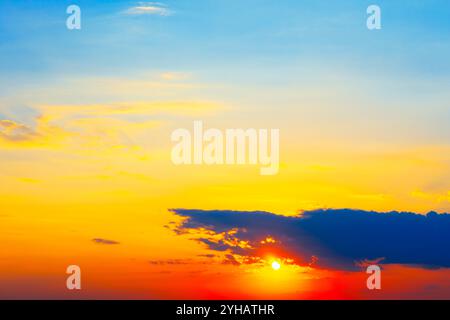 Des teintes chaudes à travers le ciel et le paysage. Ciel de coucher de soleil peint dans les tons d'orange et de rose Banque D'Images