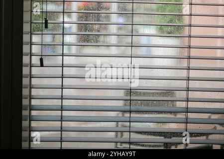 Une vue charmante et confortable donnant sur les stores par un jour de pluie avec sièges en plein air Banque D'Images