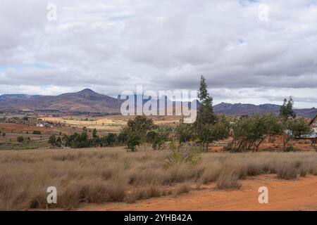 Vaste terrain agricole avec des parcelles de champs verts et bruns sous un ciel nuageux. Paysage rural, Parc National d'Isalo, Madagascar. Banque D'Images