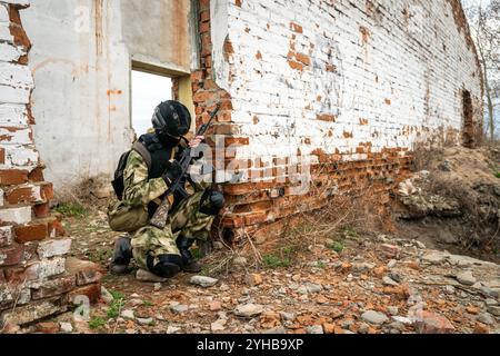Un soldat des forces spéciales recharge un fusil d'assaut. Préparation pour la bataille. Exercices militaires. Le concept de guerre et les exercices militaires antiterroristes. Banque D'Images