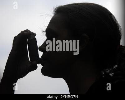 Photo du dossier datée du 25/09/08 d'une vue générale d'une femme utilisant un inhalateur. Les lacunes dans la prévention, le diagnostic et le traitement des maladies pulmonaires «étouffent silencieusement» le service de santé et «le poussent au point de rupture», a averti une association caritative. Cela vient alors que de nouvelles analyses de Asthma and Lung UK ont révélé que les maladies pulmonaires étaient responsables d'une hospitalisation d'urgence sur huit en Angleterre l'année dernière. Il a averti que le "NHS continuera à lutter" sans une "refonte audacieuse" de la manière dont les maladies pulmonaires sont prévenues, diagnostiquées et traitées. Date d'émission : lundi 11 novembre 2024. Banque D'Images