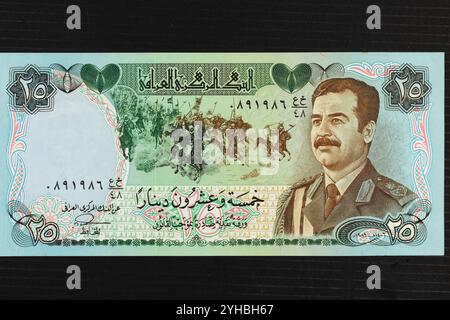 Irak 25 dinnar billet de banque à plumes portrait de Saddam Hussein avec bataille d'al-Qādisiyyah en arrière-plan Banque D'Images