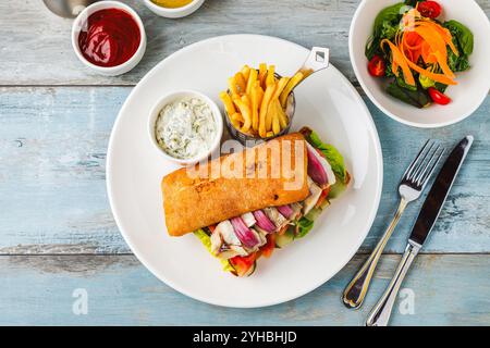 Sandwich au poisson grillé avec oignon rouge. Avec frites et sauce Banque D'Images