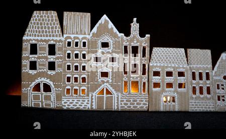 Panorama de vieilles maisons. Fabriqué à la main. Les maisons sont découpées dans du carton. Peint en blanc. Fond noir. Il y a de la lumière dans les fenêtres. Idée pour le décor. Banque D'Images