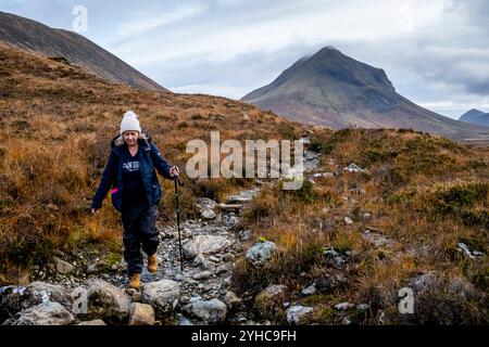 Une femme âgée faisant une randonnée à travers les Hiills/montagnes de Cuillin sur la promenade de Sligachan à Elgol, île de Skye, Écosse, Royaume-Uni. Banque D'Images