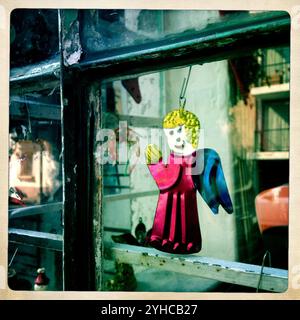 Reflet de la rue dans une fenêtre décorée d'un ange en laiton dans une maison du quartier de Condesa, Mexico, Mexique, 20 décembre 2012. REMARQUE : cette image fait partie d'Un Banque D'Images