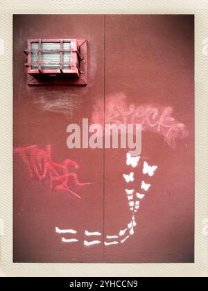 Anti-war graffiti on the side of a red building - Sacramento California Stock Photo