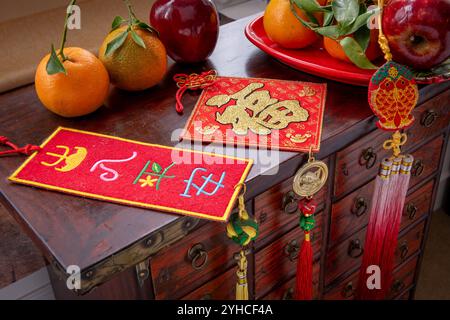 Gros plan sur la bonne fortune du nouvel an chinois, décorations bien-être avec des mandarines et des pommes rouges sur un coffre en bois. Un concept du nouvel an lunaire, backgrou Banque D'Images