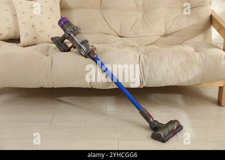 Un aspirateur sans fil reposant sur le canapé à l'intérieur Banque D'Images