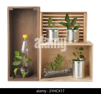 Concept de recyclage. Caisses en bois avec des plantes en bouteilles et canettes isolées sur blanc Banque D'Images