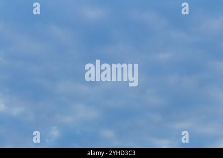 Ciel bleu vif avec des nuages d'altocumulus dispersés formant un motif texturé par une journée ensoleillée Banque D'Images