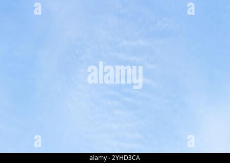 Ciel bleu vif avec des nuages d'altocumulus dispersés formant un motif texturé par une journée ensoleillée Banque D'Images