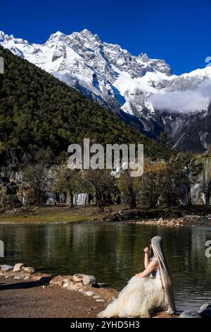 (241111) -- LIJIANG, 11 novembre 2024 (Xinhua) -- Un touriste pose pour des photos à la vallée de Lanyue (Lune bleue) à Lijiang, dans la province du Yunnan, au sud-ouest de la Chine, 9 novembre 2024. Dans le but de construire une ville touristique de renommée mondiale, Lijiang a amélioré le service dans ses sites pittoresques tels que la ville antique de Lijiang et la montagne enneigée de Yulong, dans un effort pour promouvoir le développement de haute qualité de son marché du tourisme culturel. Selon les statistiques, la ville a reçu 68,663 millions de touristes au cours des trois premiers trimestres de 2024, une augmentation de 20,71 pour cent en glissement annuel. (Xinhua/Hu Chao) Banque D'Images