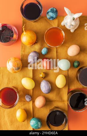 Le processus de teinture des œufs de Pâques avec des colorants naturels, hibiscus et curcuma, écorce d'oignon et chou rouge, jus de betterave, récipients de peinture et e coloré Banque D'Images