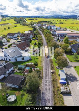 Vue aérienne d'un village avec ligne de chemin de fer, entouré de champs verdoyants et de diverses maisons, machine de bourrage, Hermann Hessebahn, Althengstett, Noir pour Banque D'Images