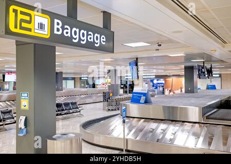 DULLES, Virginie — la zone de récupération des bagages de l'aéroport international de Washington-Dulles (IAD) dessert les passagers arrivant avec plusieurs systèmes de carrousel. Située au niveau inférieur du terminal principal, la zone comprend des affichages d'informations sur les bagages et des comptoirs de service des compagnies aériennes. Des chariots à bagages gratuits sont à la disposition des passagers. Banque D'Images