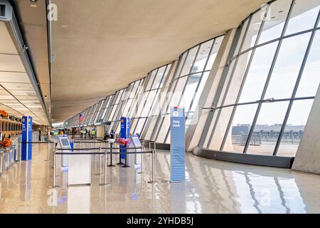 Dulles International Airport Eero Saarinen Roof Design Dulles Virginia // DULLES, Virginia — le hall supérieur de l'Aéroport International de Washington Dulles présente le design distinctif du toit incurvé d'Eero Saarinen. La structure de toit caténaire suspendue du terminal, achevée en 1962, crée un espace intérieur expansif. La conception moderniste du terminal comporte des piliers en béton soutenant la structure du toit de balayage. Banque D'Images