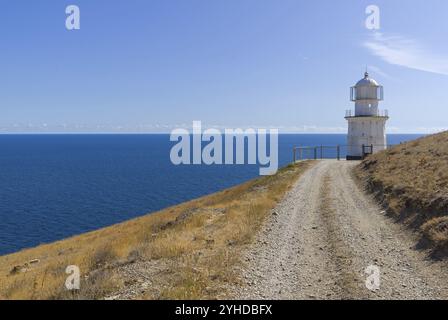 Un chemin de terre longeant une montagne déserte jusqu'à un phare au bord de la mer. Cap Meganom, Crimée, une journée ensoleillée en septembre Banque D'Images