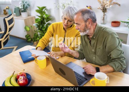 Vue surélevée d'un couple de personnes âgées caucasiennes faisant la comptabilité du ménage avec un ordinateur portable Banque D'Images