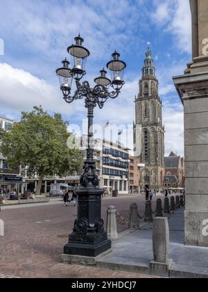 Un magnifique lampadaire antique à l'angle de l'hôtel de ville de Groningen (Stadhuis Groningen) et en arrière-plan l'imposante tour du gothique Banque D'Images