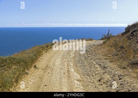 Un chemin de terre longeant une montagne déserte sur le bord de la mer. Cap Meganom, Crimée, une journée ensoleillée en septembre Banque D'Images