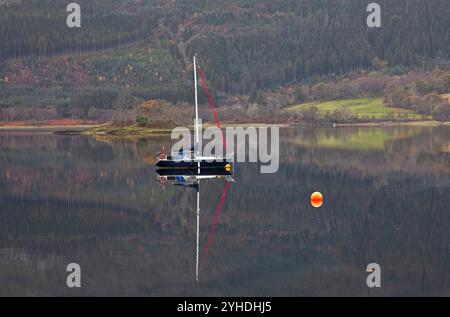 Lochaber, Écosse, Royaume-Uni. 11 novembre 2024. Temps nuageux dans les Highlands écossais avec une température autour de 11 degrés centigrades. Photo : petit voilier reflété dans les eaux tranquilles du Loch Leven, Ballachulish, Lochaber. Credit : Archwhite/Alamy Live news. Banque D'Images
