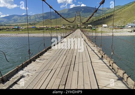 Vieux pont suspendu sur la rivière Katun dans le village Tungur. Altaï, Russie. Journée d'été ensoleillée Banque D'Images