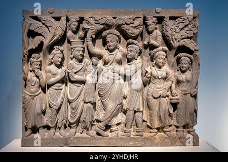 Art Gandharan naissance de Bouddha relief Washington DC // WASHINGTON DC — Un panneau en relief de schiste de l'ancien Gandhara représente la naissance de Bouddha, avec la reine Maya en robe gréco-romaine tout en assumant une pose d'esprit de la nature indienne. Créé pendant la dynastie Kushan (fin du IIe siècle - début du IIIe siècle), ce panneau faisait à l'origine partie du programme décoratif d'un stupa. La pièce illustre la synthèse culturelle caractéristique de l'art bouddhiste du Gandharan, qui a prospéré dans la région correspondant au Pakistan et à l'Afghanistan modernes. Les artistes gandharans ont combiné les traditions artistiques hellénistiques avec Bu Banque D'Images