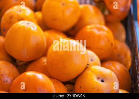 Récolte fraîche de Persimmons dans une lumière chaude Banque D'Images