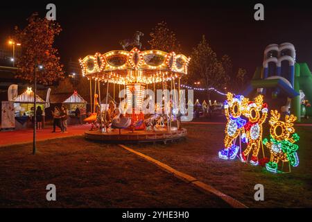 Coimbra, Portugal - 21 novembre 2023 : carrousel parisien pour enfants illuminé la nuit à Magic Land à Coimbra, Portugal. Banque D'Images