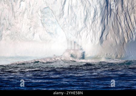 La vague s'écrase dans un énorme iceberg à Liverpool Land, au Groenland. C'est un iceberg d'eau douce qui a vêlé d'un glacier, puis a flotté dessus Banque D'Images