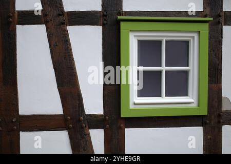 Mur blanc d'une maison à colombages avec un cadre de fenêtre vert Banque D'Images