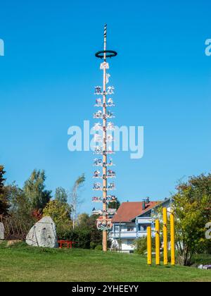 Vue sur le Maypole érigé selon la tradition ancienne à Oy-Mittelberg dans le Allgäu bavarois contre un ciel bleu d'été. Banque D'Images