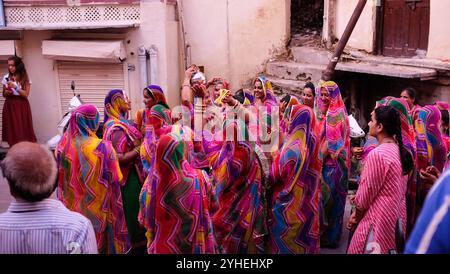 La fête nuptiale lors d'un mariage danse dans les rues d'Udaipur comme les habitants et les touristes observent Banque D'Images