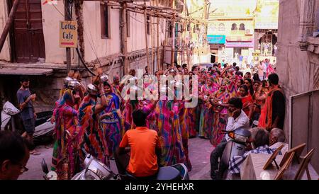 La fête nuptiale lors d'un mariage danse dans les rues d'Udaipur comme les habitants et les touristes observent Banque D'Images