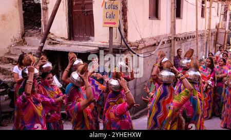 La fête nuptiale lors d'un mariage danse dans les rues d'Udaipur comme les habitants et les touristes observent Banque D'Images