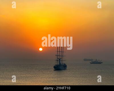 Panama City, Panama - 22 janvier 2024 : silhouette d'un voilier Windstar contre le soleil se levant à travers la brume à l'aube Banque D'Images