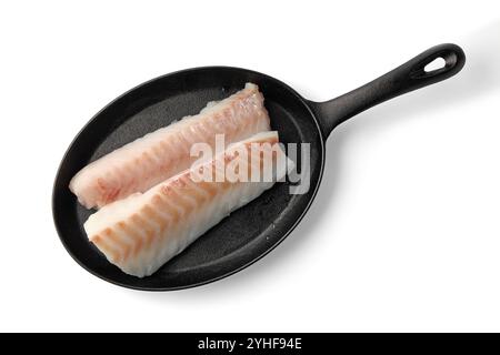 deux filets de morue de poisson de mer sur une poêle en fonte noire isolée sur fond blanc Banque D'Images