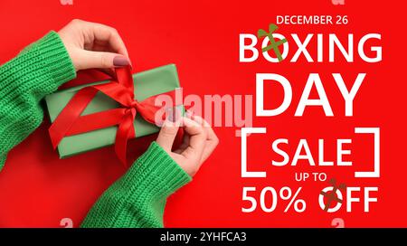 Bannière pour la vente de Boxing Day avec mains féminines tenant le cadeau Banque D'Images