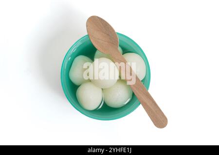 Une vue de dessus du traditionnel Rasgulla indien servi dans un bol en plastique vert, accompagné d'une cuillère en bois. Idéal pour les occasions festives indiennes. Banque D'Images