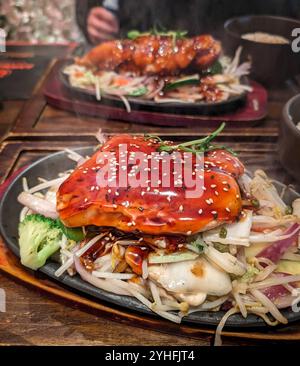 Cuisson à la vapeur de filet de saumon japonais teriyaki chaud avec des légumes sur une plaque chauffante dans le restaurant Banque D'Images