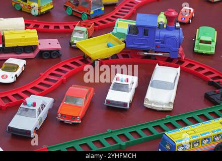 Oryol, Russie - 03 août 2024 : collecte de voitures et de trains jouets sur la surface rouge. Scène est mis en place comme si c'était ville miniature, avec des routes, Banque D'Images