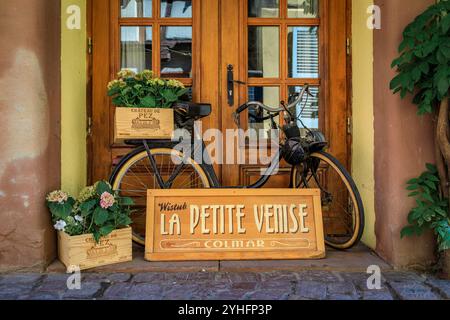 Colmar, France - 5 juin 2023 : façade ornée du restaurant winstub alsacien dans une maison traditionnelle à colombages avec des fleurs dans la petite Venise, Alsace Banque D'Images