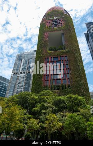 Oasia Hôtel une tour vivante à Singapour Asie est recouverte de plantes aidant à réguler la température du bâtiment par refroidissement par évaporation. Banque D'Images