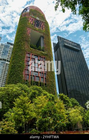 Oasia Hôtel une tour vivante à Singapour Asie est recouverte de plantes aidant à réguler la température du bâtiment par refroidissement par évaporation. Banque D'Images