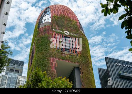 Oasia Hôtel une tour vivante à Singapour Asie est recouverte de plantes aidant à réguler la température du bâtiment par refroidissement par évaporation. Banque D'Images