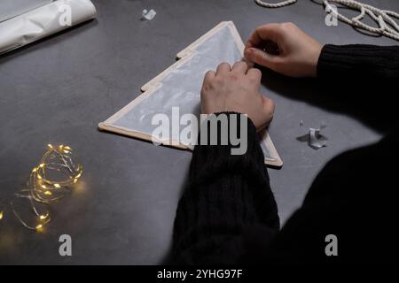 Arbre de Noël en bâtonnets de crème glacée. Idée cadeau. Faites-le vous-même instruction décoration écologique. Zero Waste Making Handmade présente les projets de bricolage des enfants. Vacances en famille. Activité créative Banque D'Images