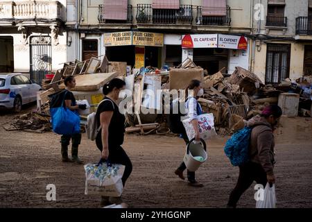 Catarroja, Espagne. 9 novembre 2024. On voit des bénévoles marcher dans les rues remplies de boue. Plus de 200 personnes ont été tuées dans les crues soudaines qui ont touché la région autour de Valence, en particulier les villes de Paiporta, SedavÃ¬ et Benatusser, dans ce qui est considéré comme la pire catastrophe naturelle de l'histoire de l'Espagne et l'une des pires de l'histoire de l'Europe. Les inondations ont été causées par un phénomène atmosphérique connu sous le nom de Dana. Des controverses ont surgi autour de la lenteur de la réponse des services d'urgence et du gouvernement. (Crédit image : © Davide Bonaldo/SOPA images via ZUMA Press Wire) USAGE ÉDITORIAL SEULEMENT! Banque D'Images