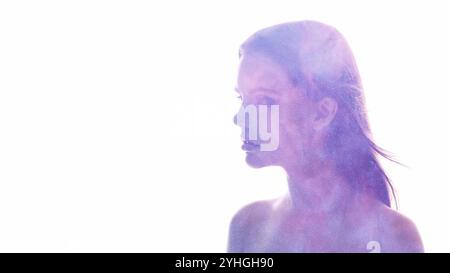 Portrait cosmique. L'énergie universelle. Flux de fumée de paillettes violettes dans la silhouette de femme double exposition isolé sur fond d'espace de copie blanc. Banque D'Images